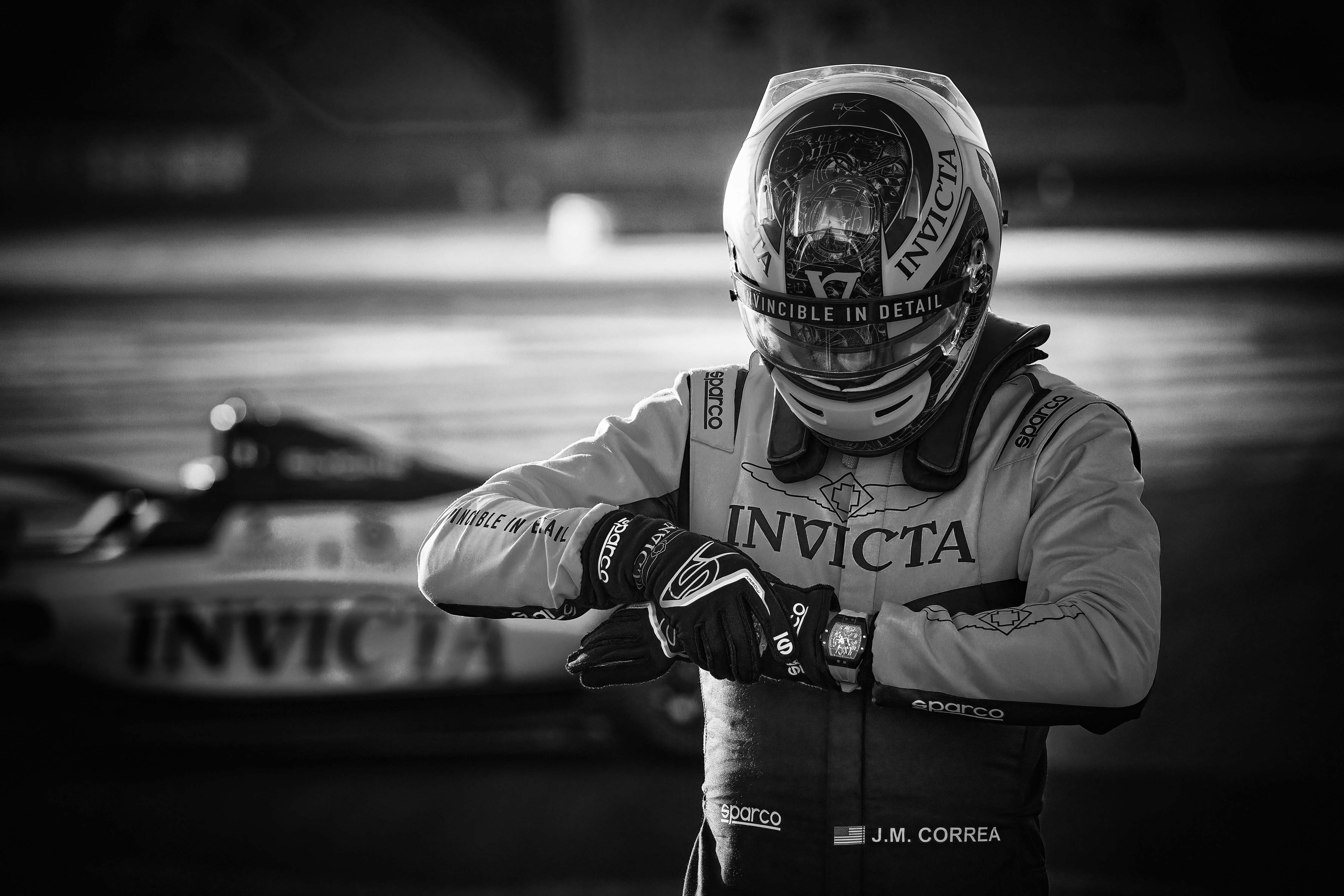 Juan Manuel Correa in racekleding en met racewagen Invicta