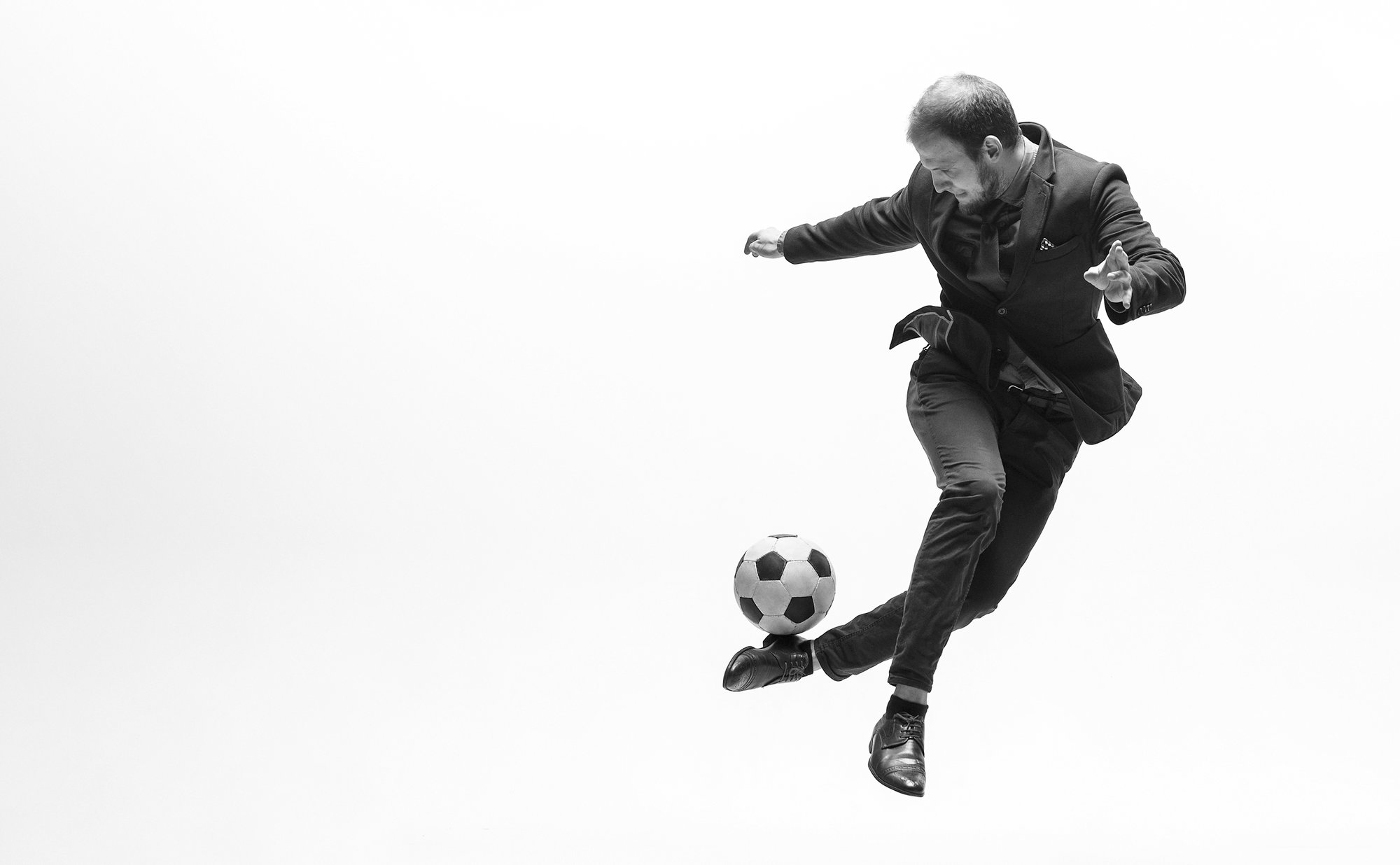 Man in pak aan het voetballen