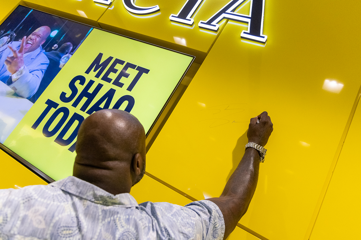 Shaquille O'Neal zet zijn handtekening op een muur in een Invicta Store in de USA